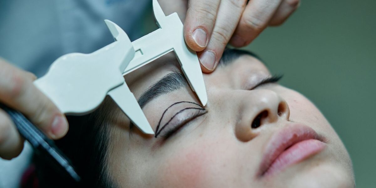 Eine Frau mit geschlossenen Augen wird auf eine Operation an den Augenlidern vorbereitet
