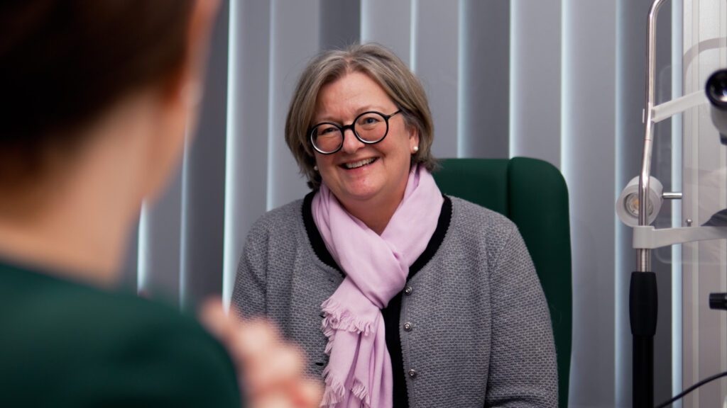 Eine glücklich lachende Patientin im Gespräch mit Roxana Fulga