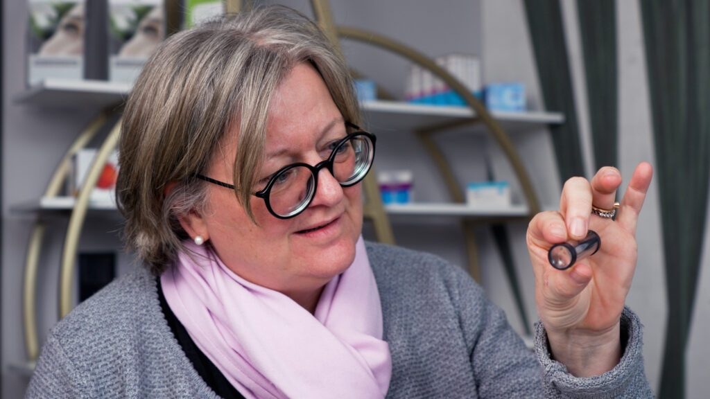 Eine Patientin bei BeyondEye schaut sich eine Linse an